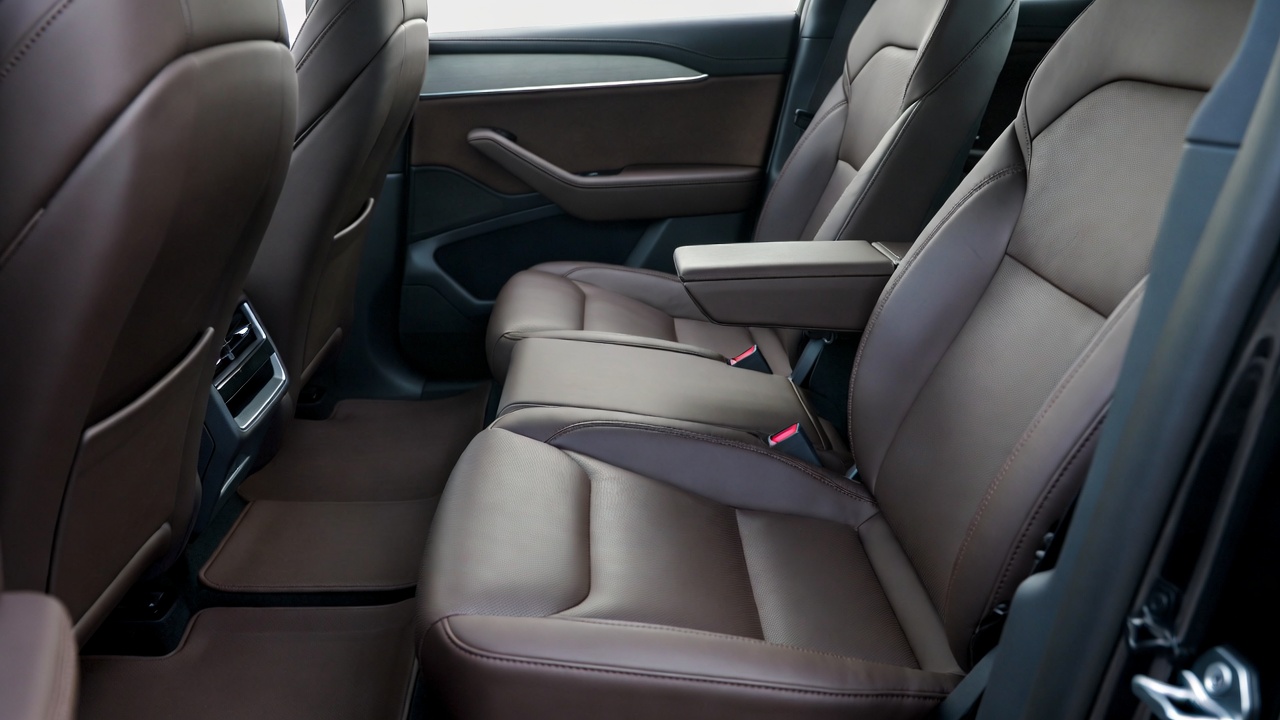 Professional interior detailing specialist with gloves cleaning luxury vehicle steering wheel